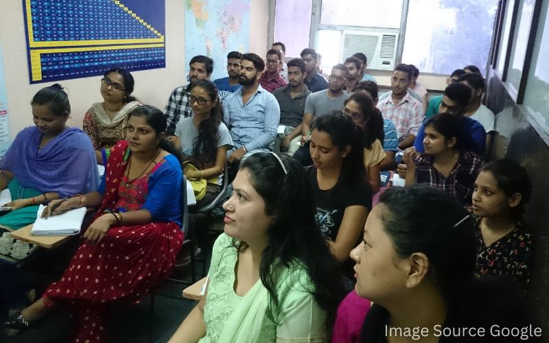 a diverse group of individuals sitting in a classroom engaged in a learning environment