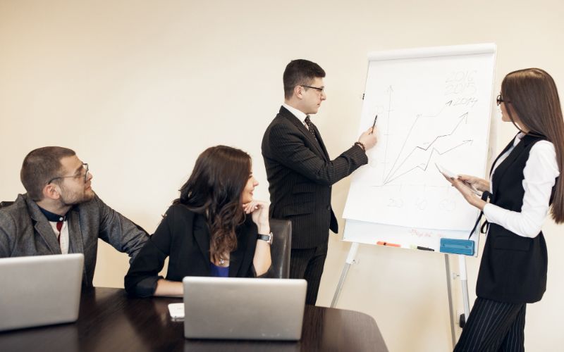 business people discussing on something with three other colleagues