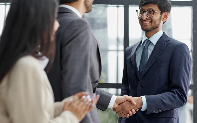 two professionals shaking hands in an office with personal development growth